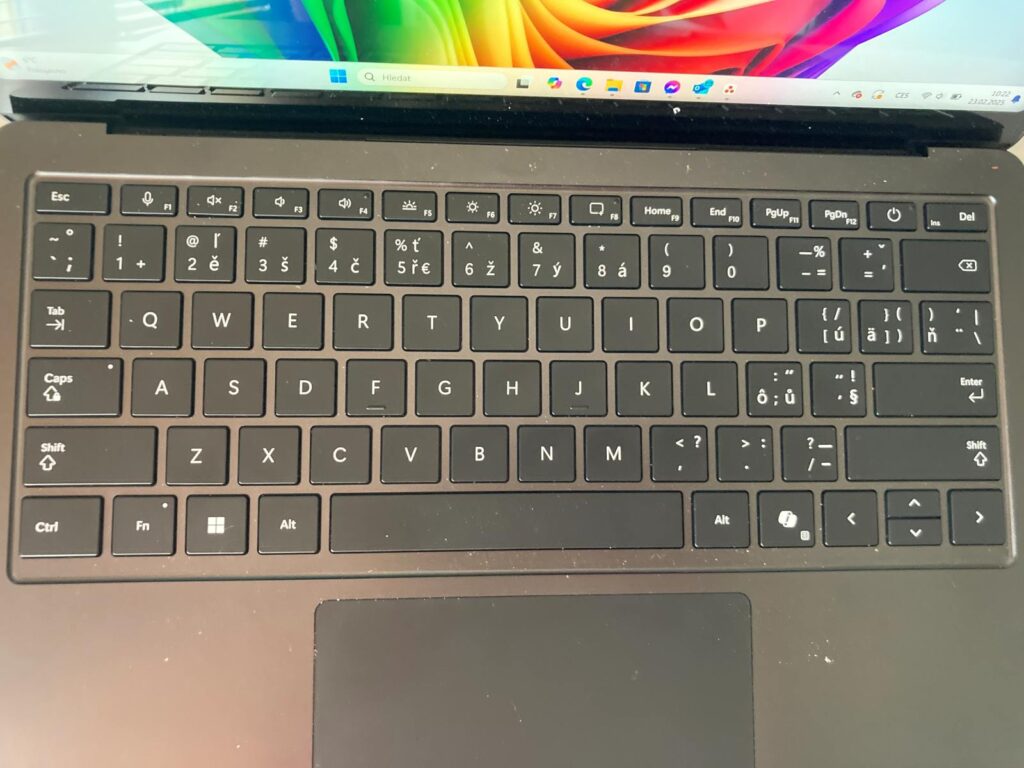 Klávesnice notebooku Microsoft Surface Laptop Gen 7 Copilot+, z níž se odlepují české znaky.